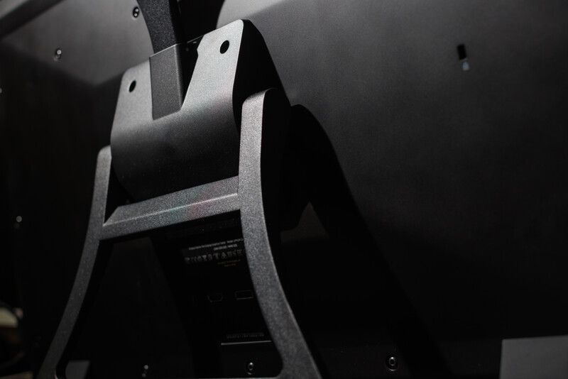 Close-up of an electric guitar's body and neck straps against a dark background.
