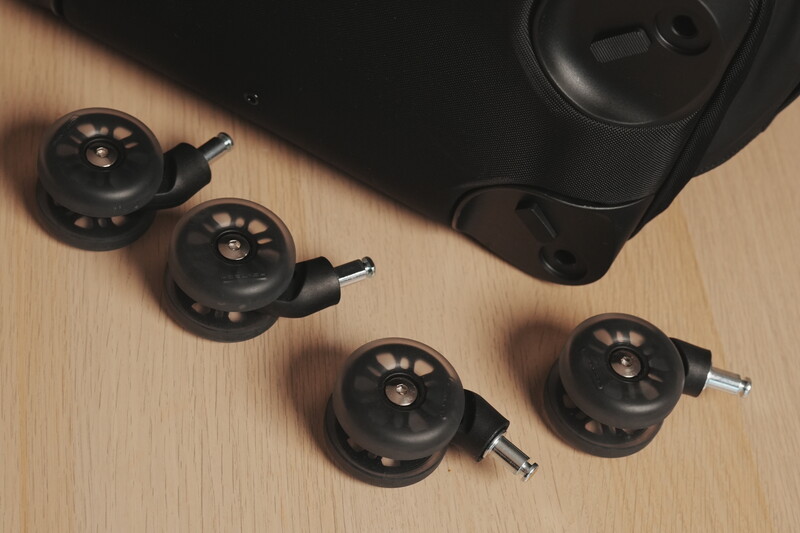 Four black wireless camera receivers and a battery pack arranged on a wooden surface with dramatic side lighting.