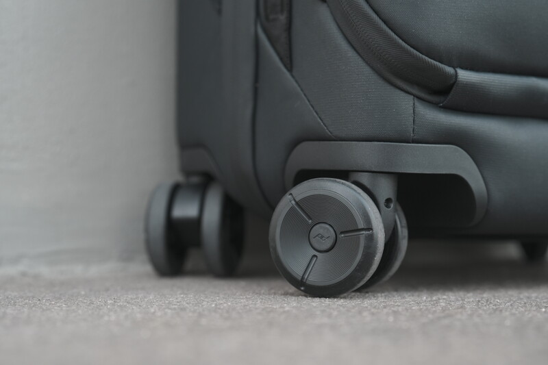 Close-up of luggage wheels and frame detail on concrete surface.