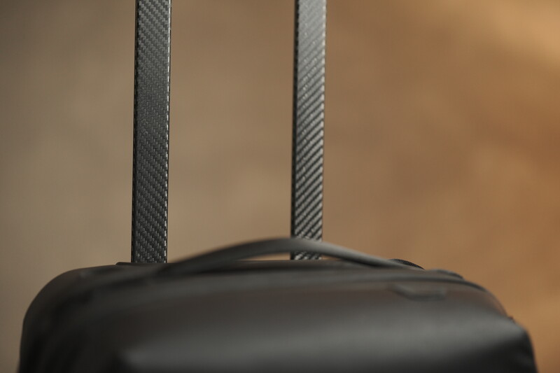 Close-up of camera strap attachment point with gray woven fabric straps and black camera body.