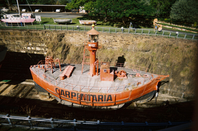 Orange lifeboat labeled 'CARPATHARIA' positioned in a stone dock or canal lock system.