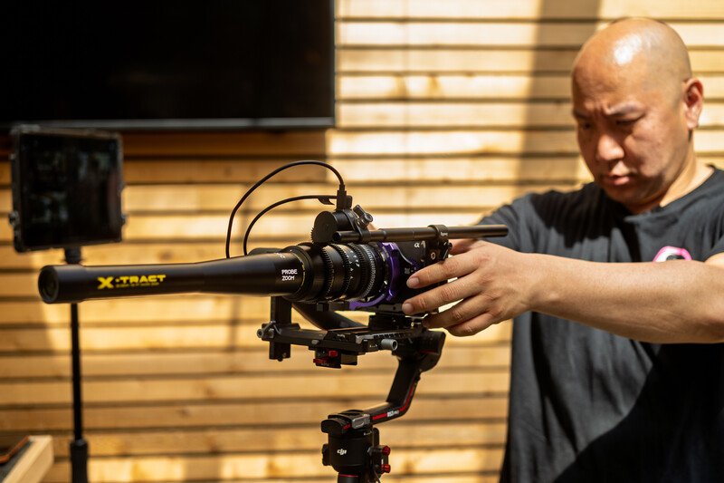 Videographer adjusts a cinema camera mounted on a stabilizer rig in a studio setting.