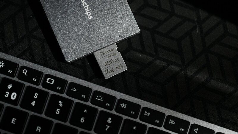 External SSD connected to laptop keyboard in flat lay composition.