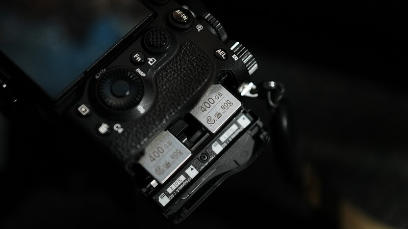 Overhead view of a professional camera body with dual battery compartments and control dials visible.