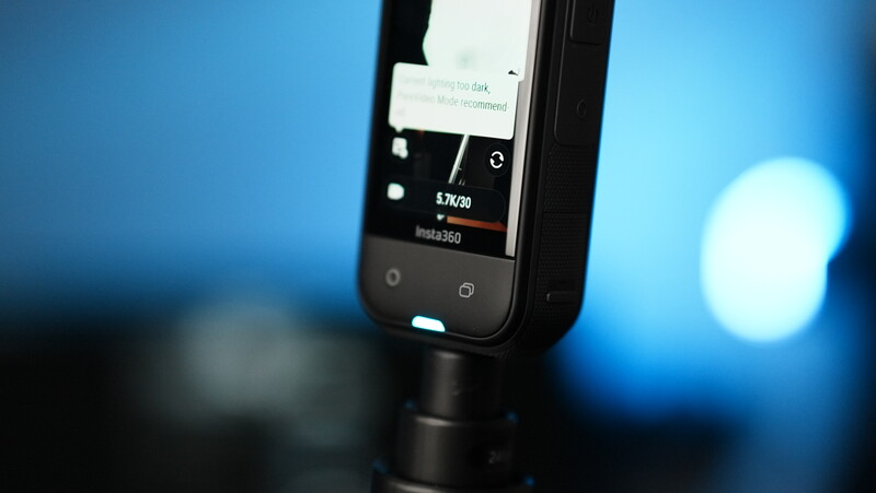 Smartphone mounted on a stabilizer rig displaying a photo editing interface with blue bokeh background.