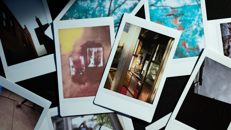 Scattered Polaroid-style instant film photographs overlapping on a surface, showing various indoor and outdoor scenes.