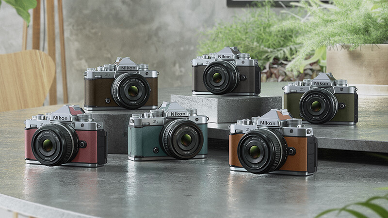 Six vintage Nikon rangefinder film cameras in various color finishes arranged on a concrete surface.