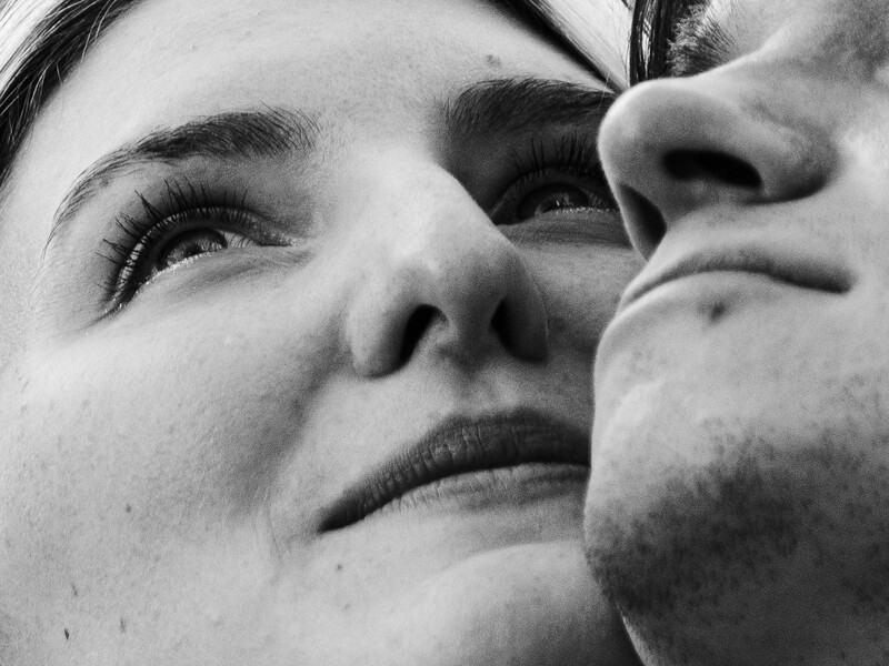 Black and white close-up portrait of two faces in profile, nearly touching, with soft focus and shallow depth of field.