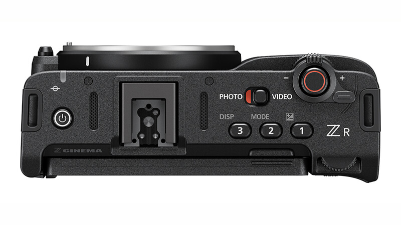 Top-down view of a mirrorless camera body showing control buttons, mode dial, and hot shoe.