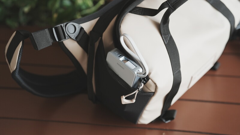 White and black VR headset with straps resting on a wooden surface outdoors.