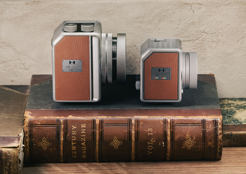 Two vintage instant cameras with orange leather bodies displayed on antique leather-bound books.