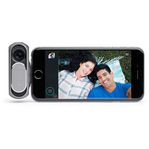 Smartphone with dual-lens camera module displaying portrait photo of two people on screen.