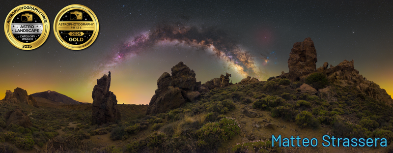 Rocky desert landscape beneath the Milky Way galaxy at dusk, with warm golden light on the horizon.