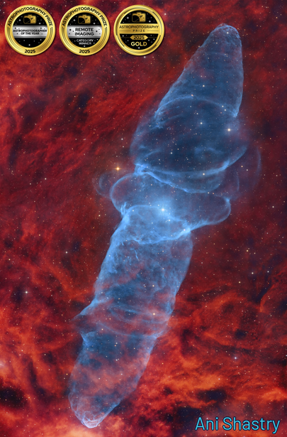Nebula with blue filament structure against red and orange gas clouds in deep space.