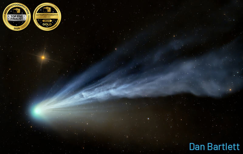 A comet with a bright blue nucleus and sweeping dust tail against a starfield.