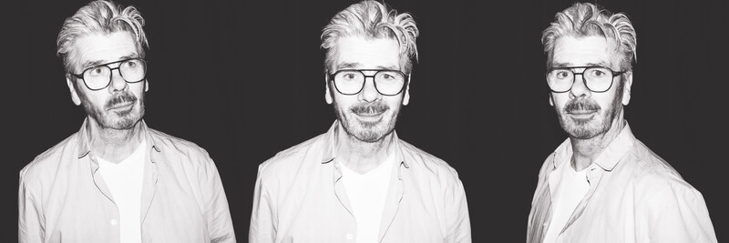 Black and white portrait triptych of a man wearing glasses and light shirt, shot from three slightly different angles against dark background.