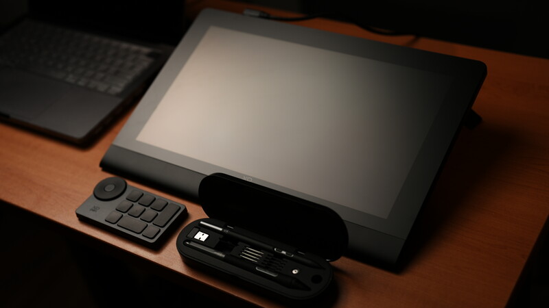 Tablet and accessories arranged on a wooden desk with warm lighting.