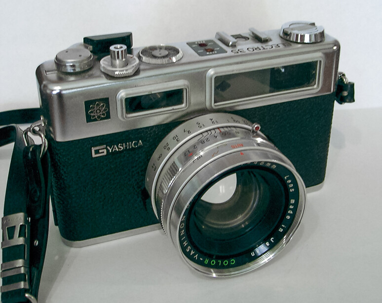 Yashica rangefinder camera with dark green body and chrome top plate, featuring a standard lens.