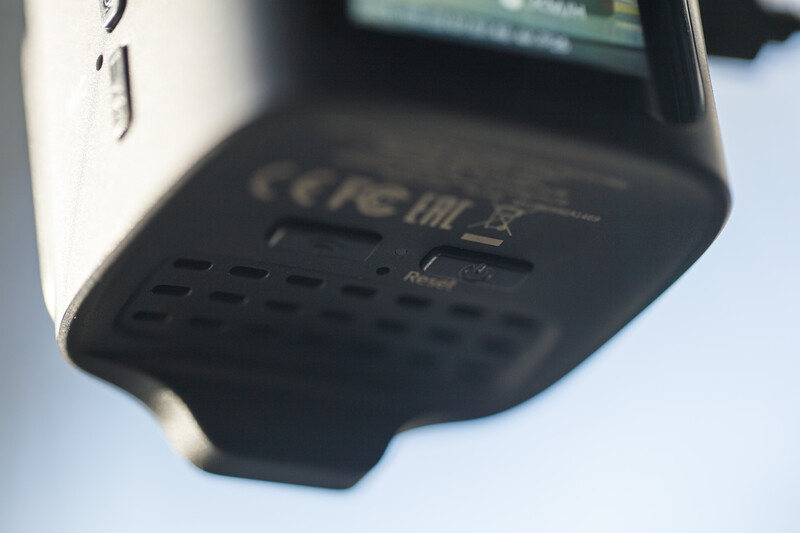 Close-up of camera flash unit bottom showing ventilation grilles and regulatory markings.