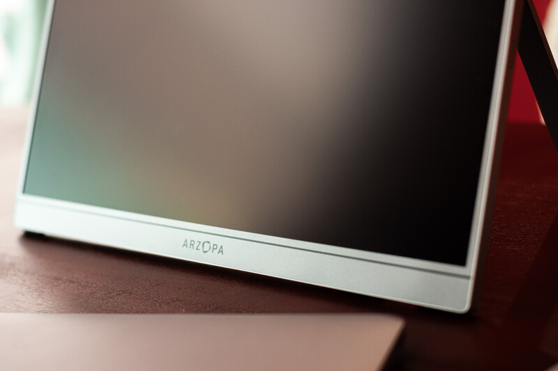 Arzopa portable monitor with white bezel displayed at an angle on a wooden surface.