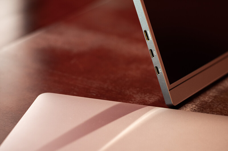 Laptop with silver edge viewed at angle on warm-toned surface with soft directional lighting.