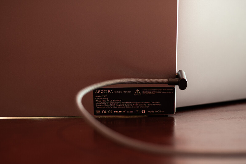 Power adapter with coiled cable on warm-toned surface against gradient background.