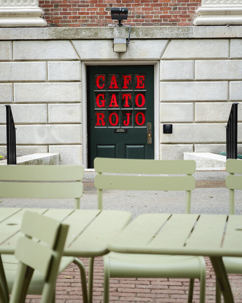 Photograph of Cafe Gato Rojo with green chairs in the foreground
