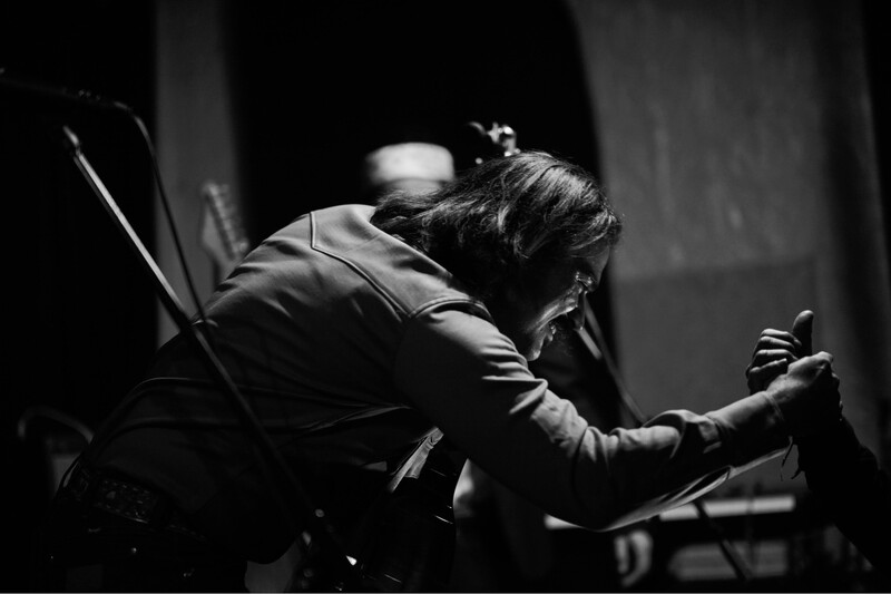 A guitarist greeting a fan from stage.