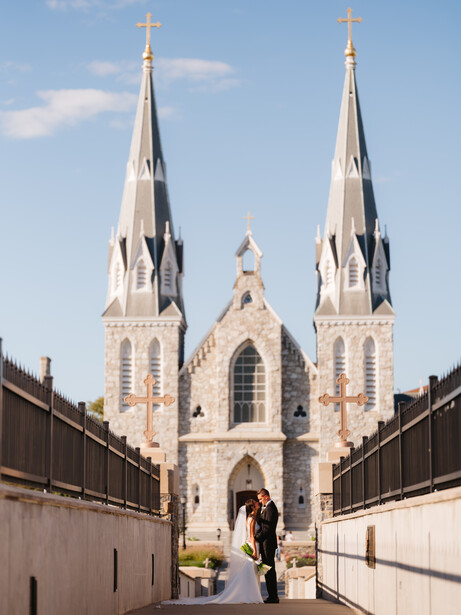White church with twin spires and central dome framed by symmetrical concrete walls.