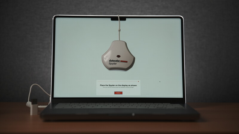 Laptop displaying a sensor setup screen with a pear-shaped device hanging from the top of the monitor.