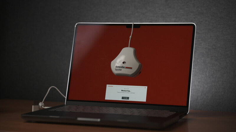 Laptop displaying a red screen with a hanging air freshener graphic and loading message.