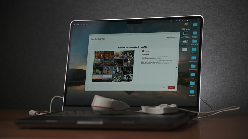 Laptop displaying a portfolio website with grid layout of photography images and text content.