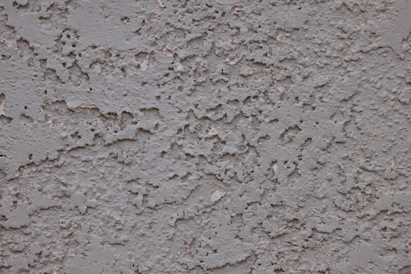 Close-up texture of rough concrete or cement surface with aggregate and weathered finish.