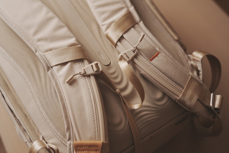 Overhead view of three cream-colored canvas camera bags with leather accents and metal hardware arranged closely together.