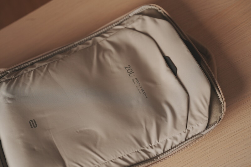 Overhead view of a light gray padded camera bag or equipment case on a wooden surface.