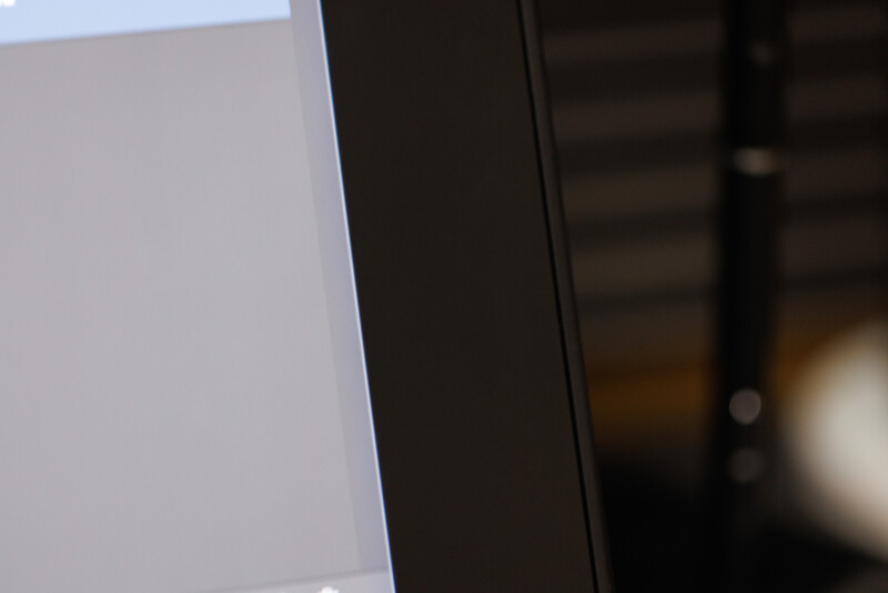 Close-up of a white surface meeting a dark edge, with blurred background elements.