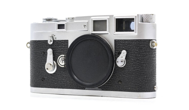 Vintage rangefinder camera with chrome top plate and black textured leather body.