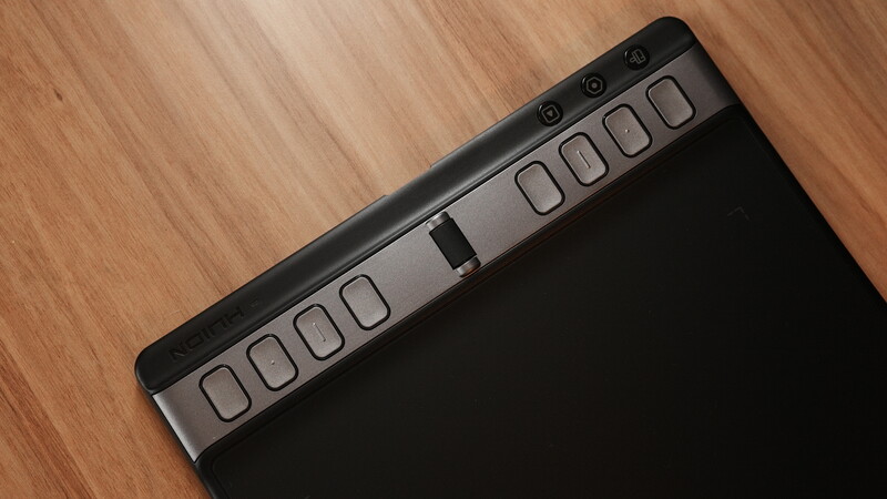 Top view of a MIDI controller keyboard on a wooden surface showing illuminated pads and control buttons.