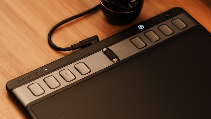 MIDI keyboard controller with 16 velocity-sensitive pads and faders on wooden surface.