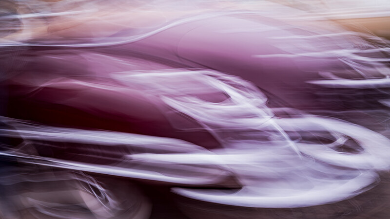 Abstract motion blur with swirling purple, lavender, and white tones creating a dynamic, flowing composition.
