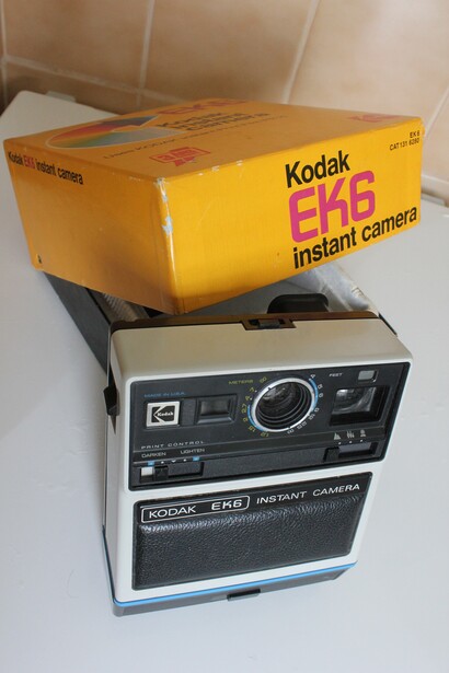 Vintage Kodak EFP instant camera with original yellow box packaging displayed on white surface.