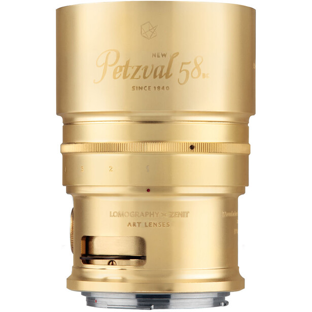 Zeiss Milvus 1.4/85 lens in gold finish, shown against white background with focus ring and depth-of-field markings visible.