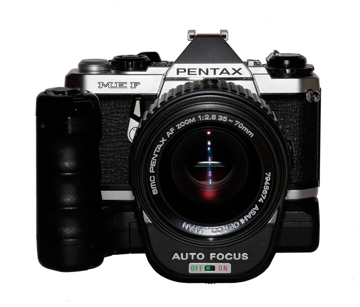 Pentax MV1P SLR camera with motor drive attachment and standard zoom lens.