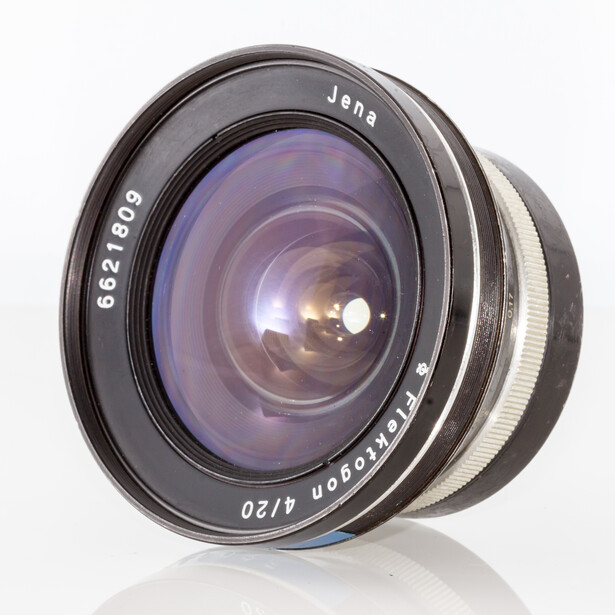 Vintage wide-angle lens with purple-coated glass elements and engraved specifications on black barrel.