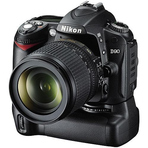 Nikon D90 DSLR camera with attached zoom lens and battery grip against white background.