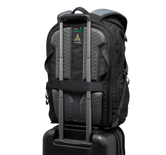 Black camera backpack with gray straps mounted on a rolling luggage handle.