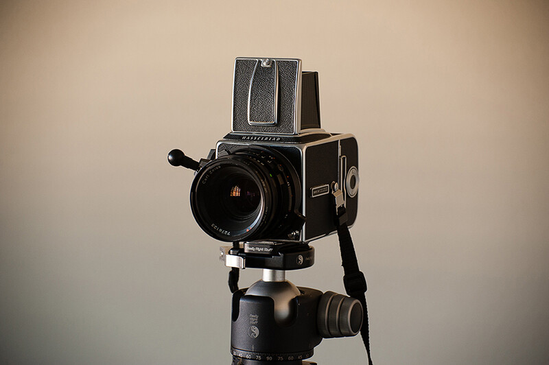 Hasselblad 500-series medium format camera mounted on a ball head tripod against a neutral background.