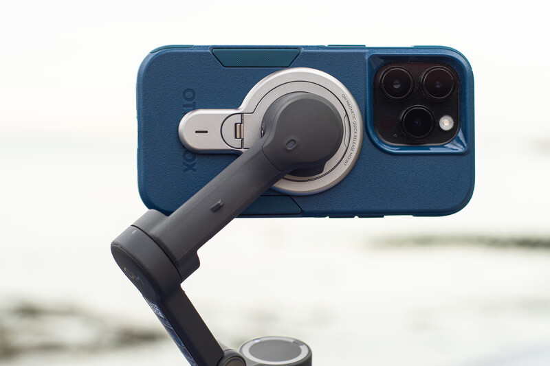 Blue smartphone mounted on a gimbal stabilizer with camera array visible at top.
