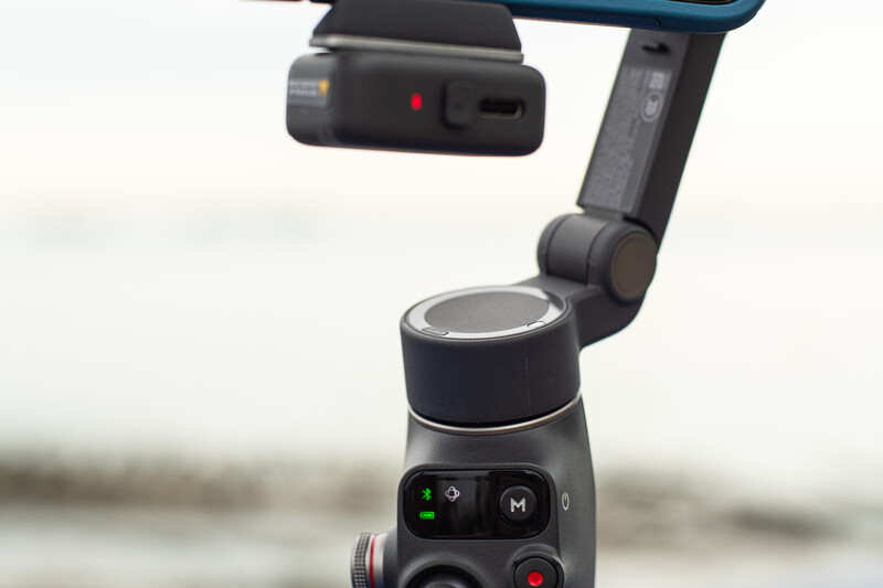 DJI Osmo Mobile gimbal with smartphone mounted on top and control panel visible below.