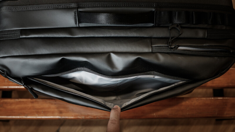 Black camera bag or carrying case opened to show empty white interior compartment.